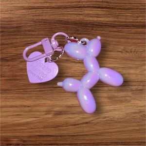 Bright purple & iridescent, balloon dog keychain with a playful design